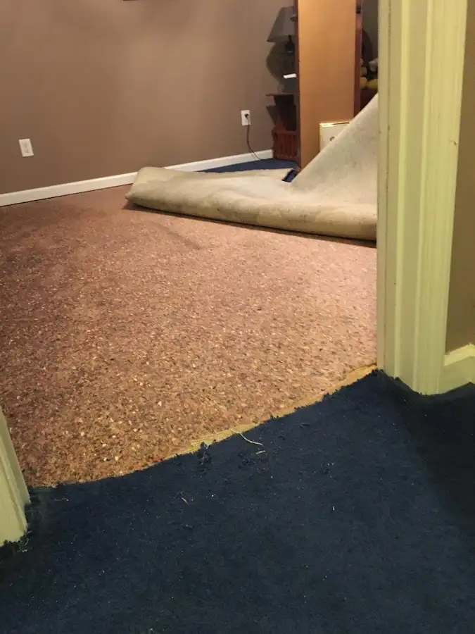 Carpet pad removal revealing water damage during Water Mitigation Services in Laurinburg
